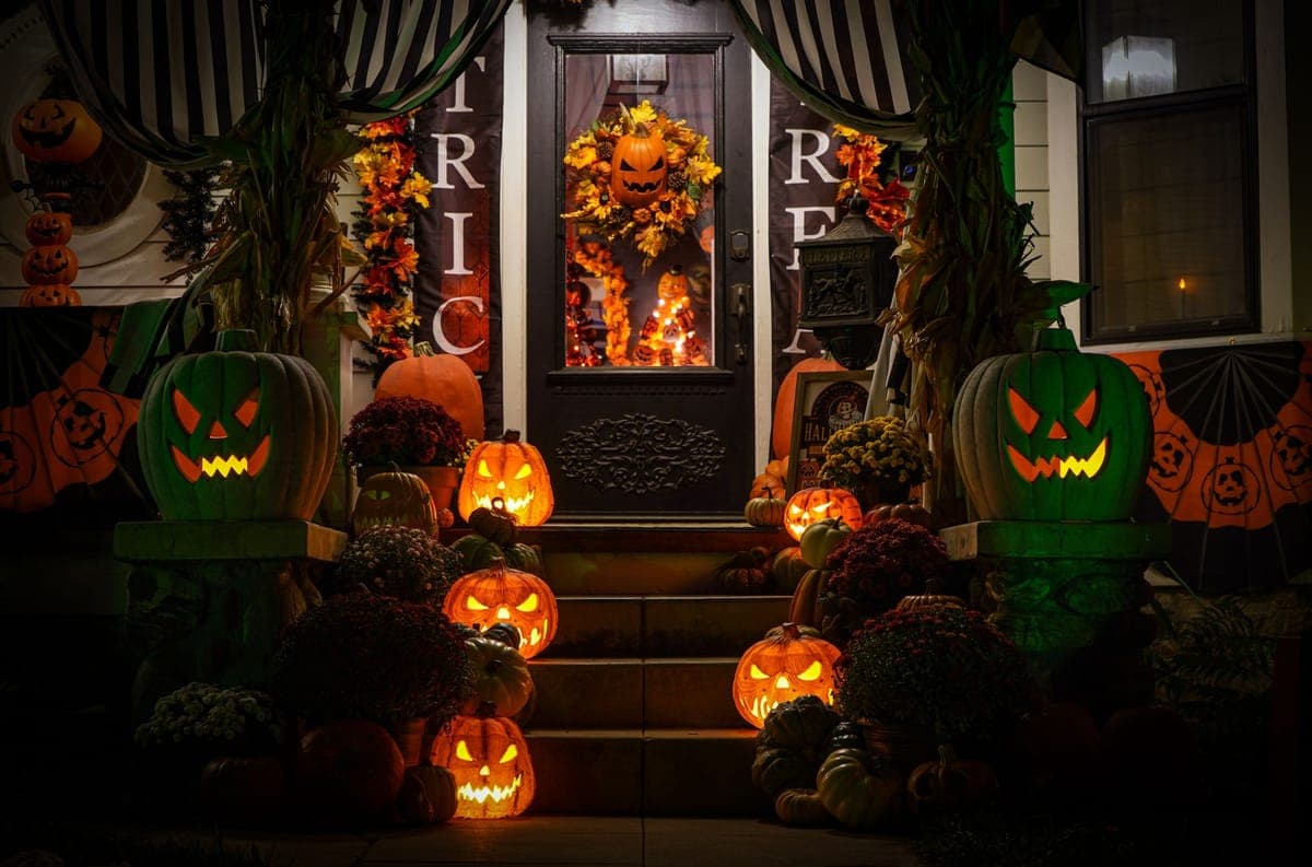 A simply decorated porch lit with colored light on a dark evening