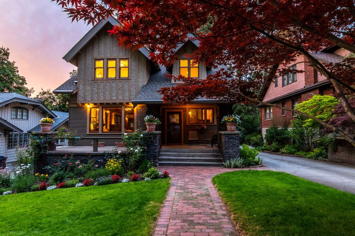 A decorated front yard viewed from the sidewalk at night