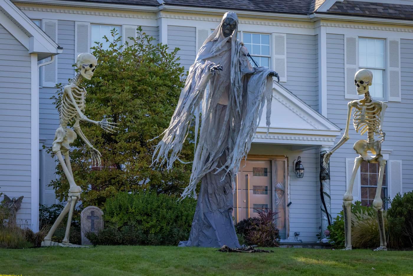 Lit inflatable decorations on a suburban front lawn after dark