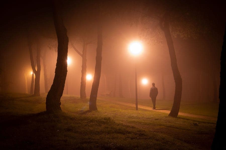 Low fog rolling across a lawn between gravestone props at night