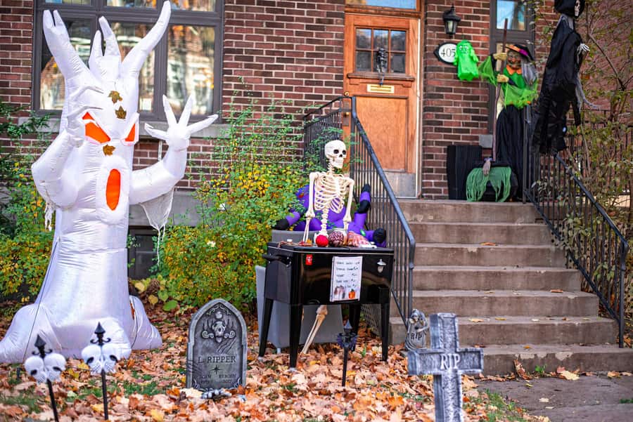 A lit inflatable character standing on a lawn against a dark house